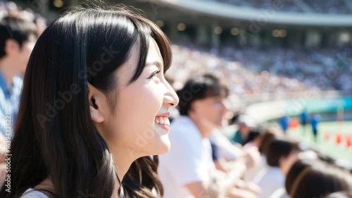 Young Japanese Woman Fan Smiling and Watching a Game in a Stadium Crowd