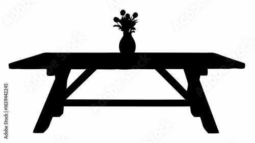 Silhouette of a wooden table with a vase of flowers on top creating a simple and elegant still life scene
