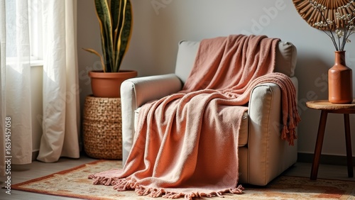 Cozy living room chair with pink blanket and indoor plants in sunlit space