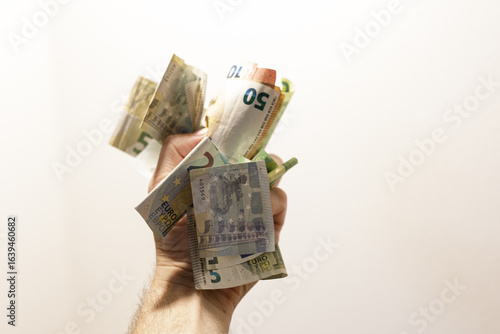 A hand holding various euro...