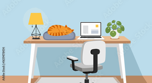 Cozy workspace with sleeping ginger cat, laptop, lamp, and potted plant