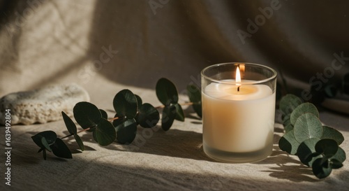 Calming tabletop with a lit scented candle in a frosted jar
