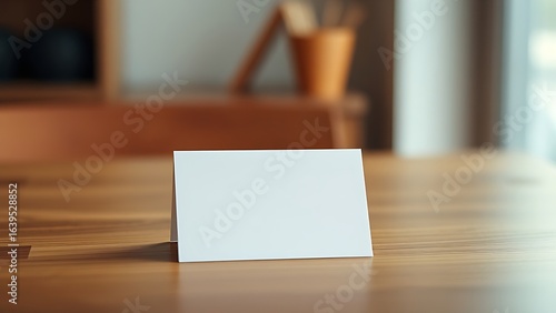 A blank notecard placed on a wooden desk with soft diffused lighting and shallow focus.