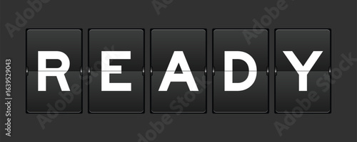 Black color analog flip board with word ready on gray background