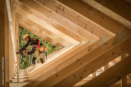 Construction Worker Builds Wooden Framework of Modern House in Daylight
