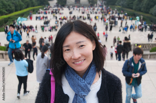 happy chinese woman with blurred people background nanjing china