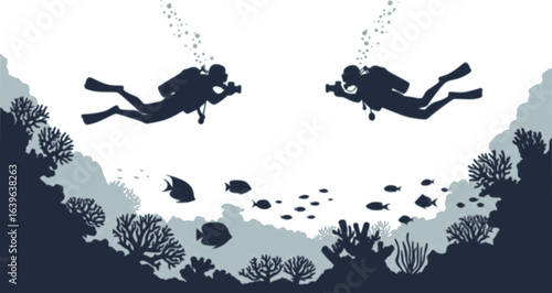 Silhouette of two scuba divers with cameras swimming underwater near coral and fish in the ocean water
