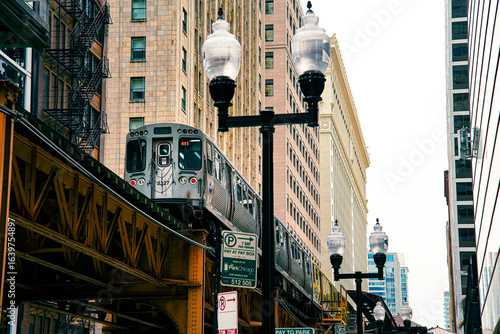 Fototapeta Naklejka Na Ścianę i Meble -  Chicago elevated train (L train) in downtown cityscape with historic buildings, urban architecture, public transportation, travel USA, street view, skyline, city life.