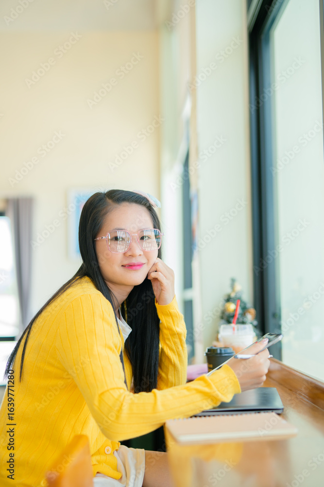 Smiling young Asian student wearing headphones talking on online chat using laptop. Smiling young Asian student wearing headphones talking on online chat using laptop.