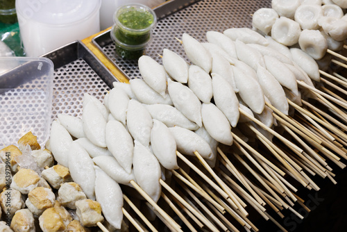 White rugby-shaped fish balls, boiled and skewered. Street food in Thailand.
