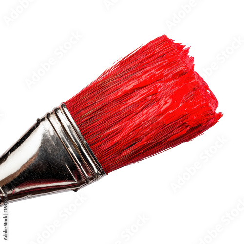 Bright red paintbrush resting against a clean surface highlights vibrant color ready for artistic creation
