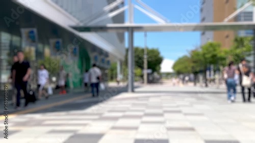 夏の駅前広場と歩く人々（手持ち）