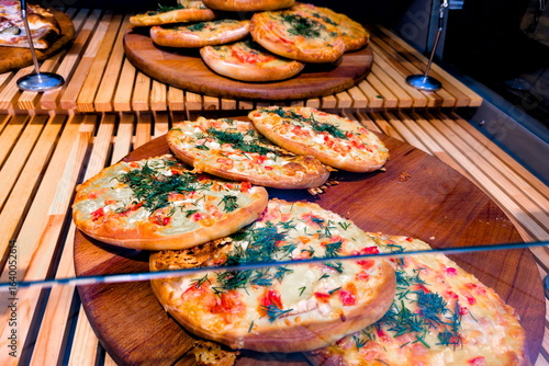 Принти на полотні Freshly baked savory pastries displayed on wooden trays in a cozy cafe during th