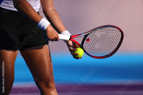 Female tennis player preparing serve with racket and ball on outdoor court