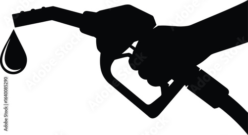 Hand holding gasoline pump nozzle with dripping fuel