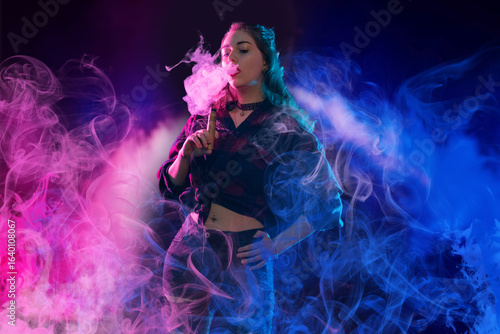 Young woman exhales colorfu...