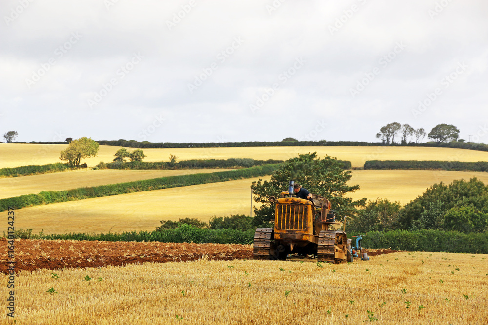 Fototapeta premium Vintage tractor ploughing a field 
