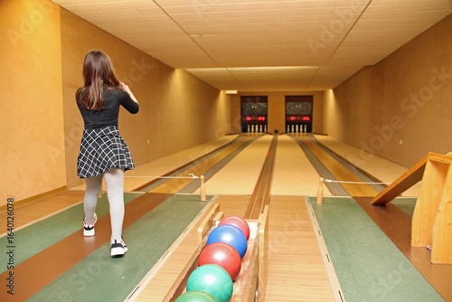 Mädchen kegelt auf einer Kegelbahn