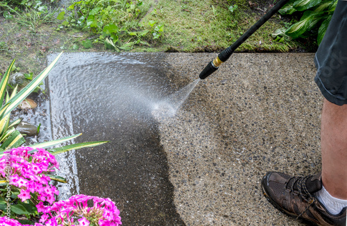 Man washing off dirt off the concrete surface, close up view. 