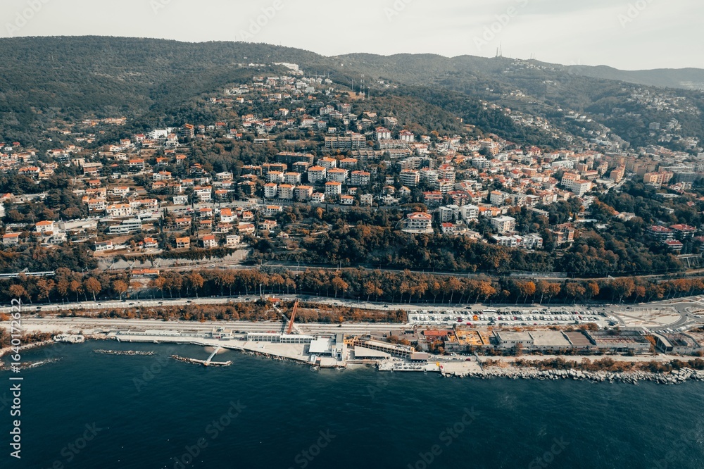 Fototapeta premium Aerial view of a coastal city with hills.