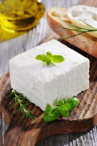 Wallpaper Mural Fresh feta cheese block on rustic wooden cutting board with olive oil and herbs for Gourmet Cooking Torontodigital.ca