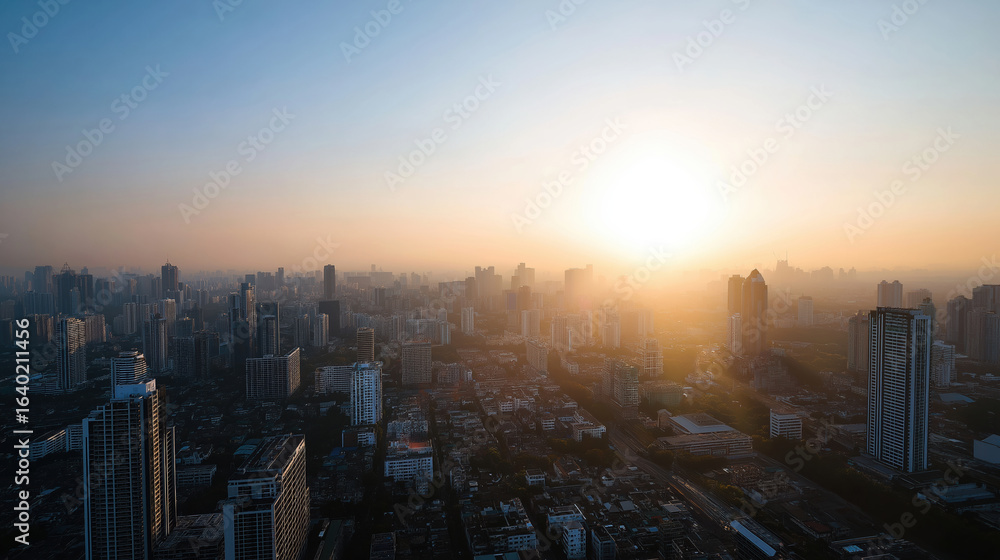 Fototapeta premium Urban skyline at sunset with a hazy atmosphere over the cityscape