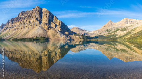  Crystal clear Bow Lake reflecting rugged mountains in Banff National Park