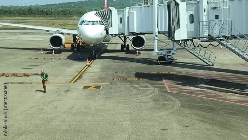 Time—lapse footage of aircraft ground handling at the airport gate - docking with a teletrap, actions of ground staff and operations with luggage, filmed in accelerated mode.
