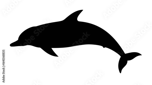 Silhouette of a dolphin swimming gracefully in the ocean with its dorsal fin and tail clearly visible