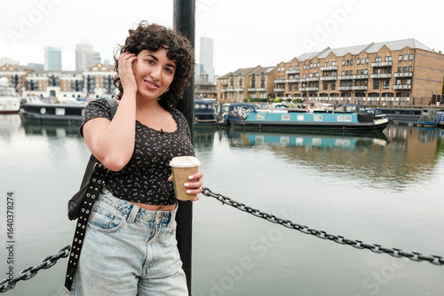 Photography Young woman enjoying coffee by the limehouse basin marina in london