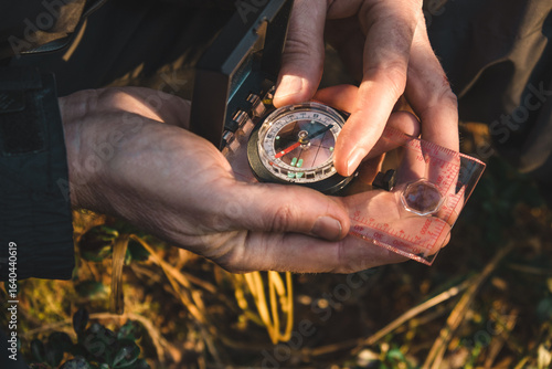 Papier peint two male hands hold compass while person appears focused on navigating through dense forest on sunny day