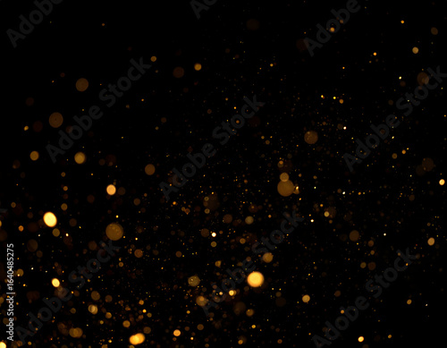 Elegant shimmering gold dust and glowing particles creating a magical bokeh effect on a black background.