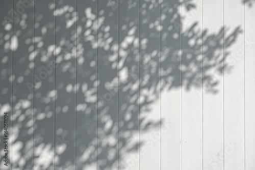 Fototapeta Light and shadow, showcasing the dappled sunlight filtered through palm fronds onto a textured, light-colored surface