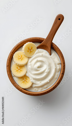 Yogurt in a wooden cup with bananas.