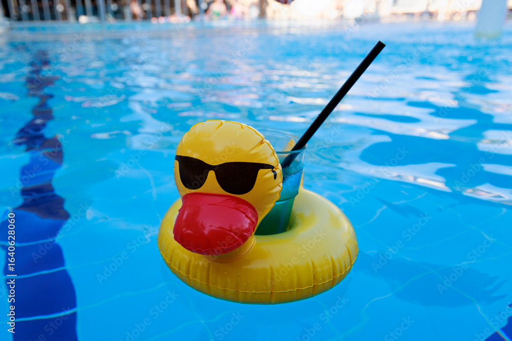 Summer Beach composition with inflatable mini duck with cold drink floating in the pool. Fashion party concept. Summer Beach composition with inflatable mini duck with cold drink floating in the pool. Fashion party concept.