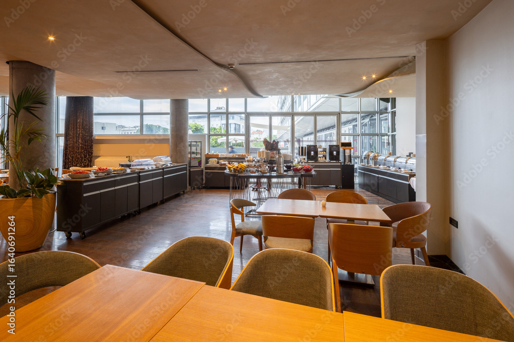 Fototapeta premium Interior of a hotel restaurant with breakfast served on buffet tables