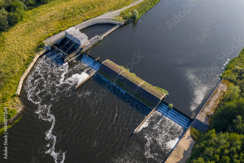 Top-down aerial view of Woolston Weir on the River Mersey in Warrington, a hydroelectric facility harnessing the river’s flow, with water cascading over the structure