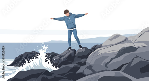 A young man standing on rocks by the sea, arms outstretched, enjoying the seascape and ocean breeze illustrating freedom and adventure