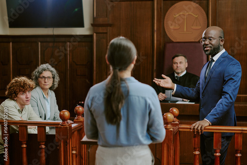 Quadro su tela Black middle aged man in suit addressing Caucasian young adult woman standing in