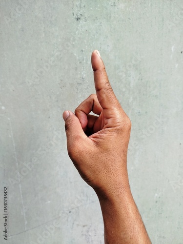 Raising hand of man on grey background