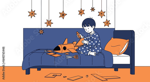 Enthusiastic young boy in star pajamas creates a cardboard rocket on his bed in his room