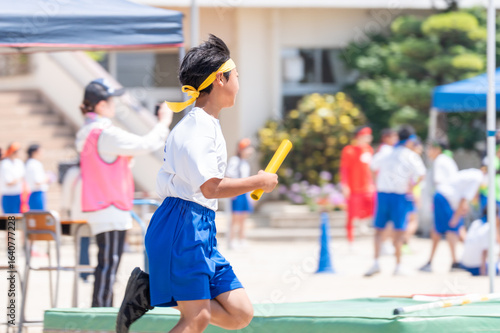中学校の体育祭でリレーを走る男子生徒