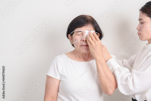 Elderly Woman with Eye protecting by Eye Pad for concepts of Eye disease, Cataract, Glaucoma, Age Related Macular Degeneration, Diabetic Retinopathy, Vitreous, Conjunctivitis, World Glaucoma day