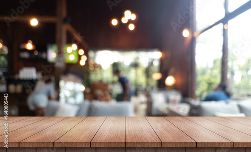 	
Empty wooden table top with lights bokeh on blur restaurant background.