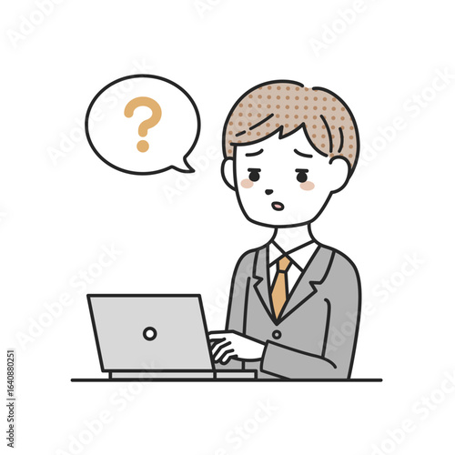 パソコンの前で考えるスーツを着た男性