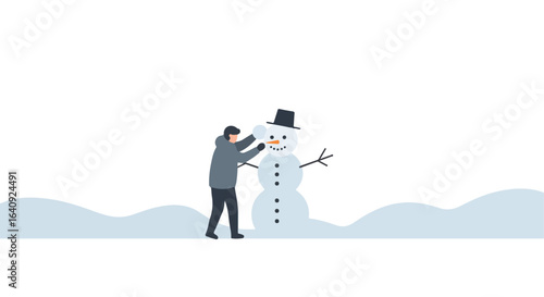 Person in coat building a snowman outdoors with hat and carrot in winter snow