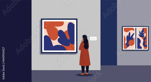 Woman in a museum viewing abstract art hanging on the wall in a gallery space