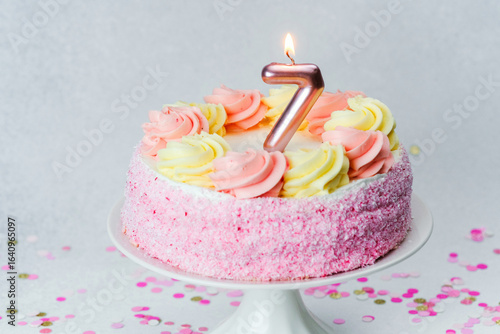 Birthday cake with pink and yellow frosting celebrating seventh birthday