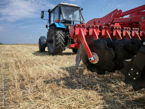 фотографія Large industrial disk plow red color for tilling soil in the field