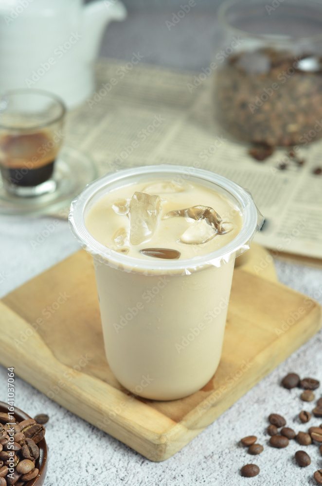 Ice coffee in a plastic cup with brown sugar and ice cubes and beans Ice coffee in a plastic cup with brown sugar and ice cubes and beans